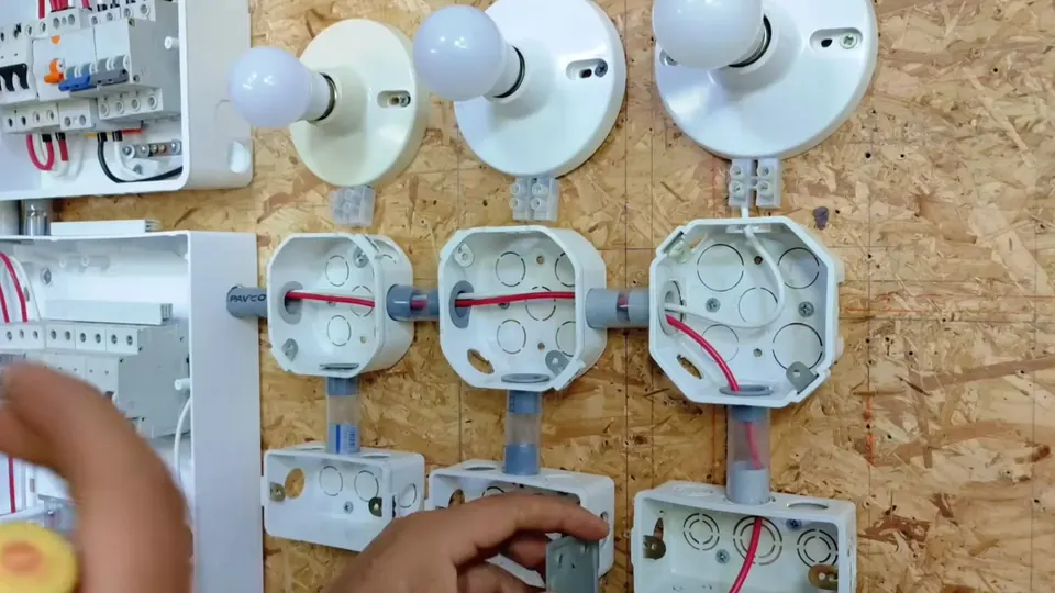 Aula prática de instalação elétrica com lâmpadas e caixas de passagem