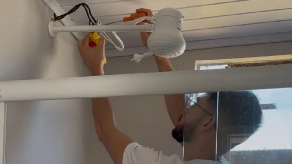 Instrutor instalando um chuveiro elétrico