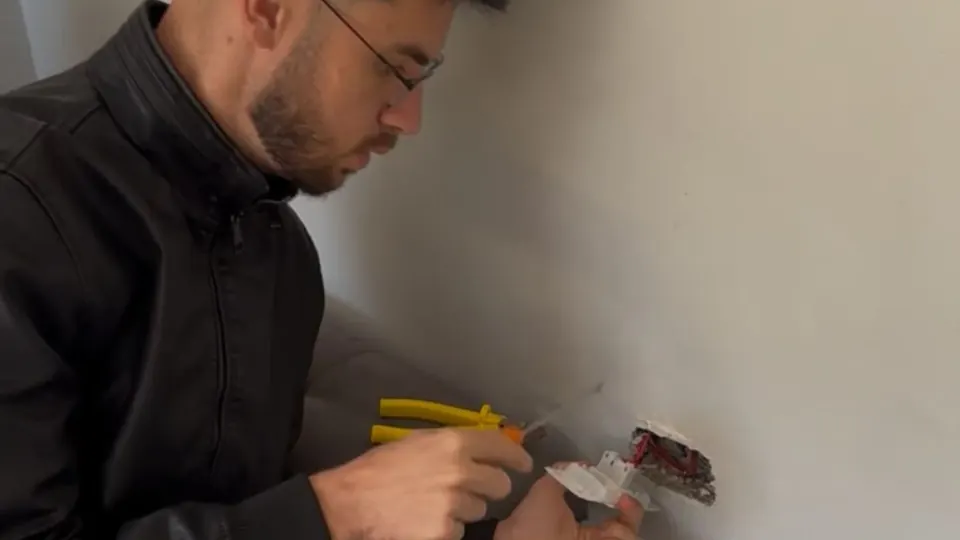 Instrutor realizando uma instalação elétrica residencial