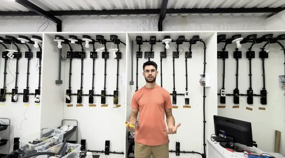 Instrutor em frente ao painel de instalações elétricas residenciais